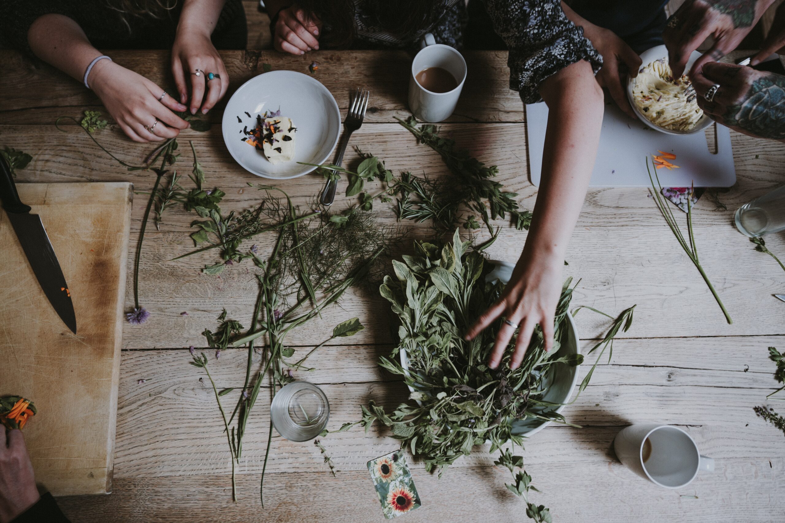 variety of dried herbs being sorted on a wooden table