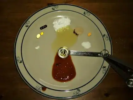 Liquid supplements on a plate with a red blob at the six o'clock position