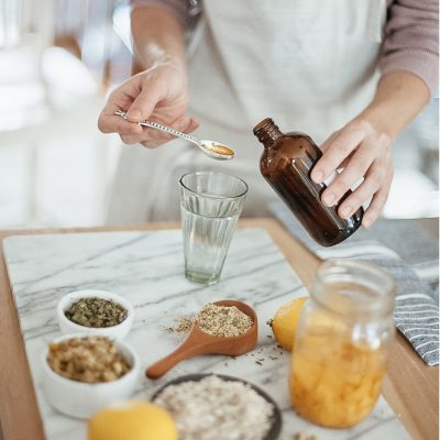 Woman measuring oil for herbal recipe