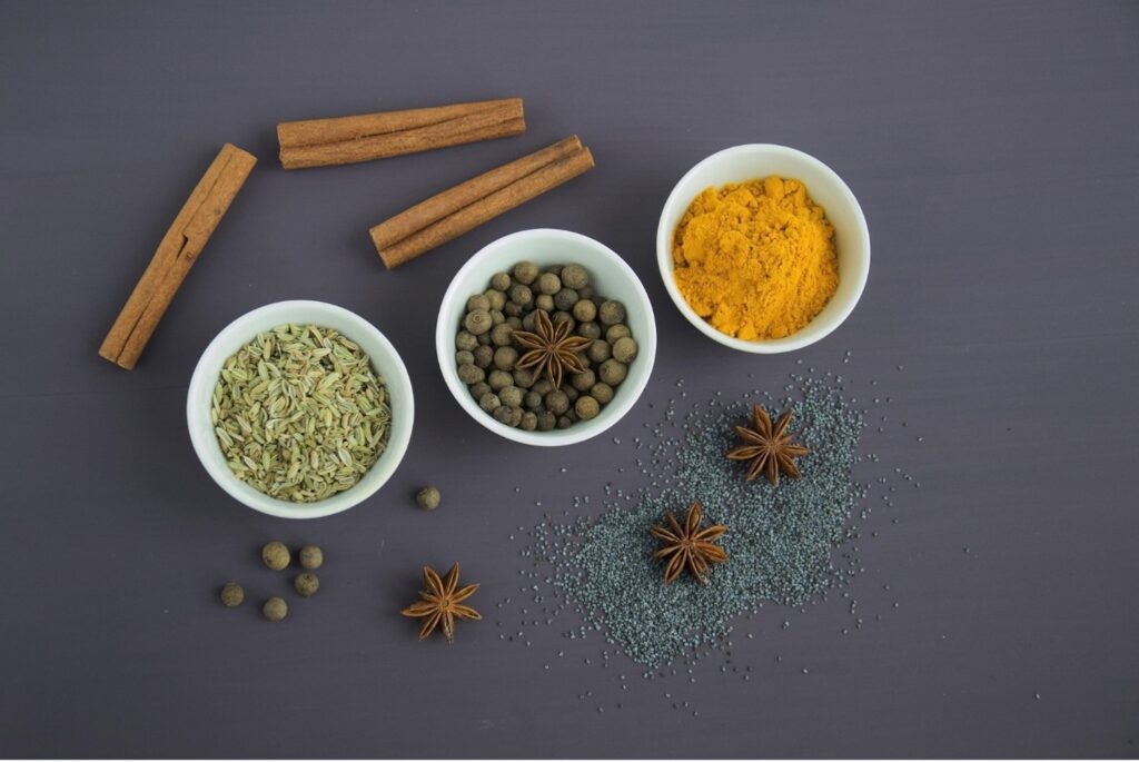 Cinnamon sticks with herbs in bowls